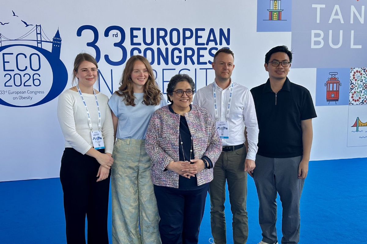 Five people stand in front of a sign for the 33rd European Congress on Obesity (ECO 2026) with blue carpeting and conference badges visible.