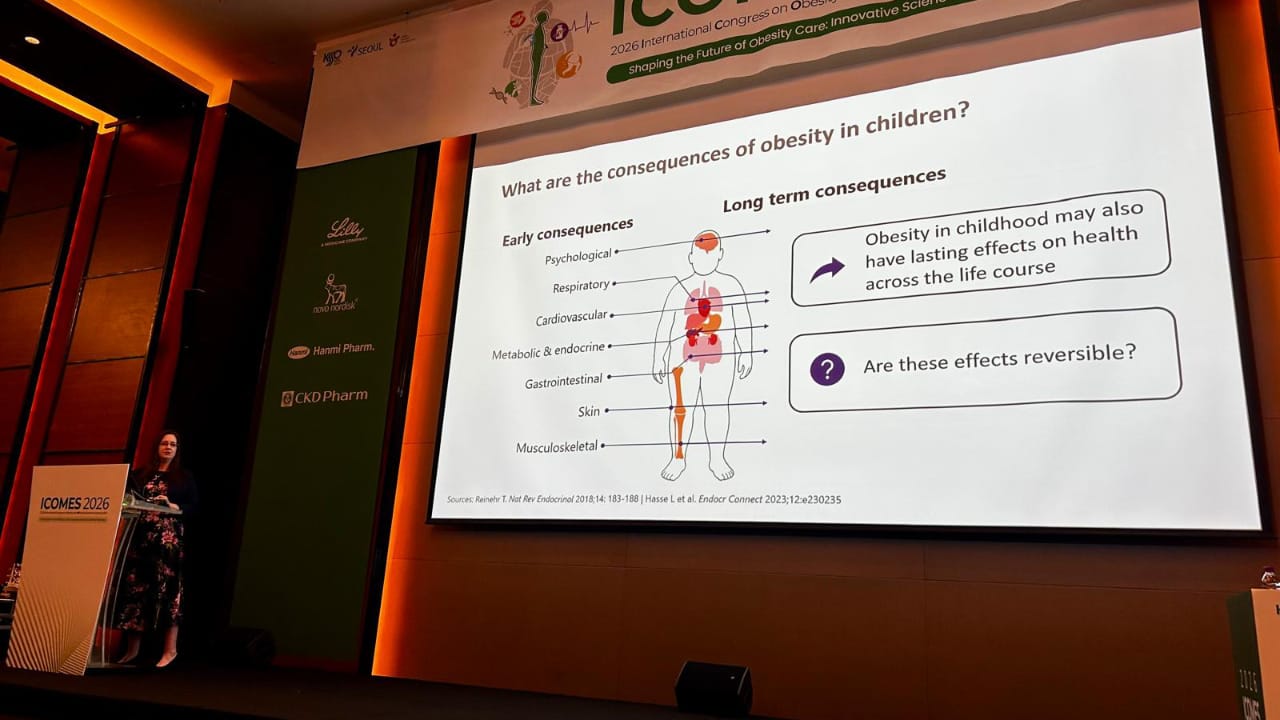 A woman presents a slide about the consequences of obesity in children at a conference, summarising early and long-term health impacts with text and simple medical graphics.